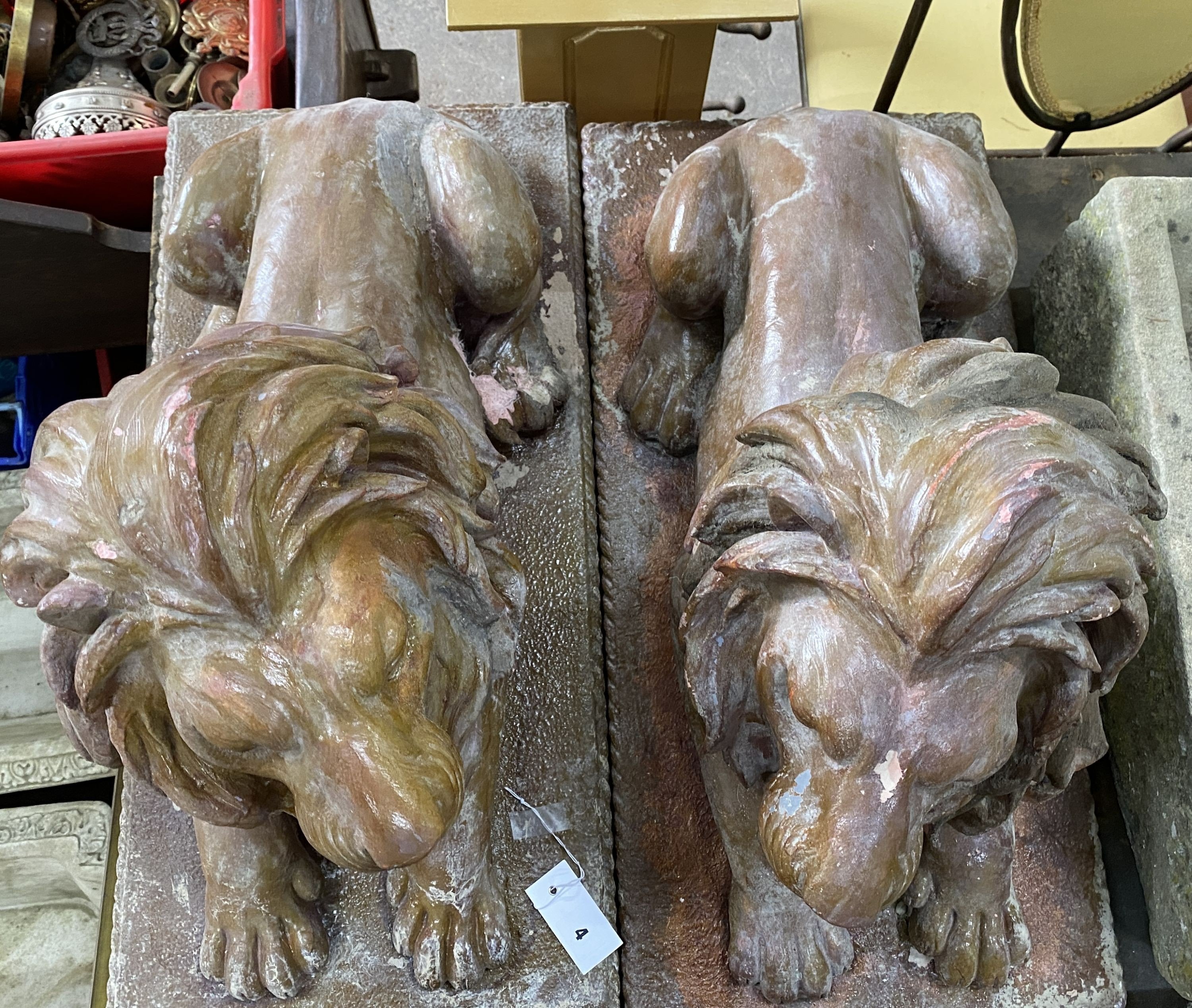 A pair of faux terracotta resin recumbent lion garden ornaments, length 74cm, width 36cm, height 50cm